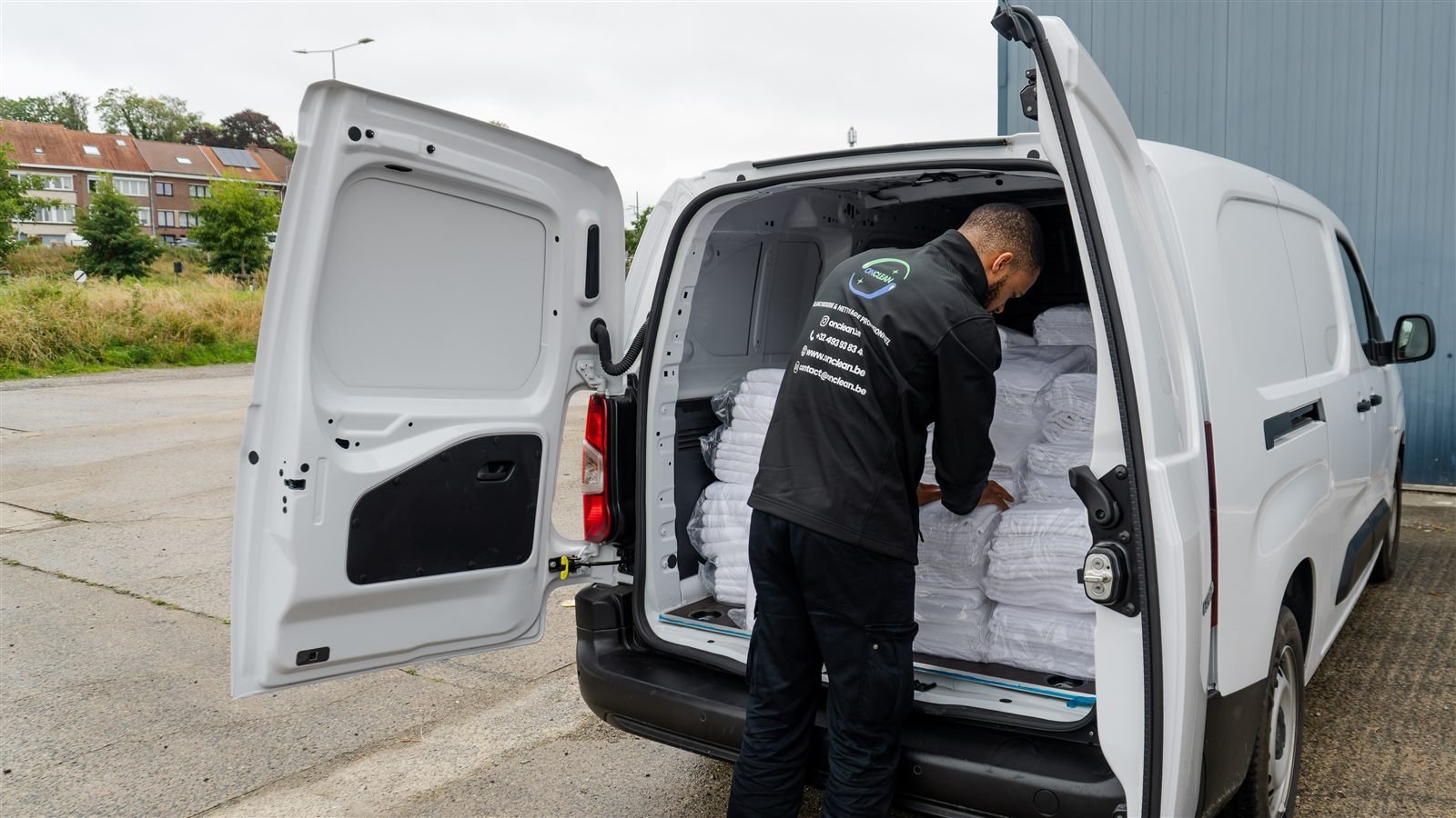 Livreur OnClean chargeant la camionnette de linge propre