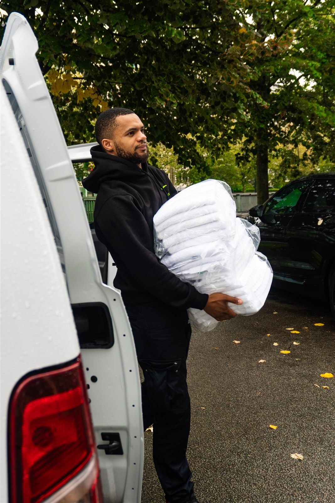 Livreur souriant portant une pile de linge propre