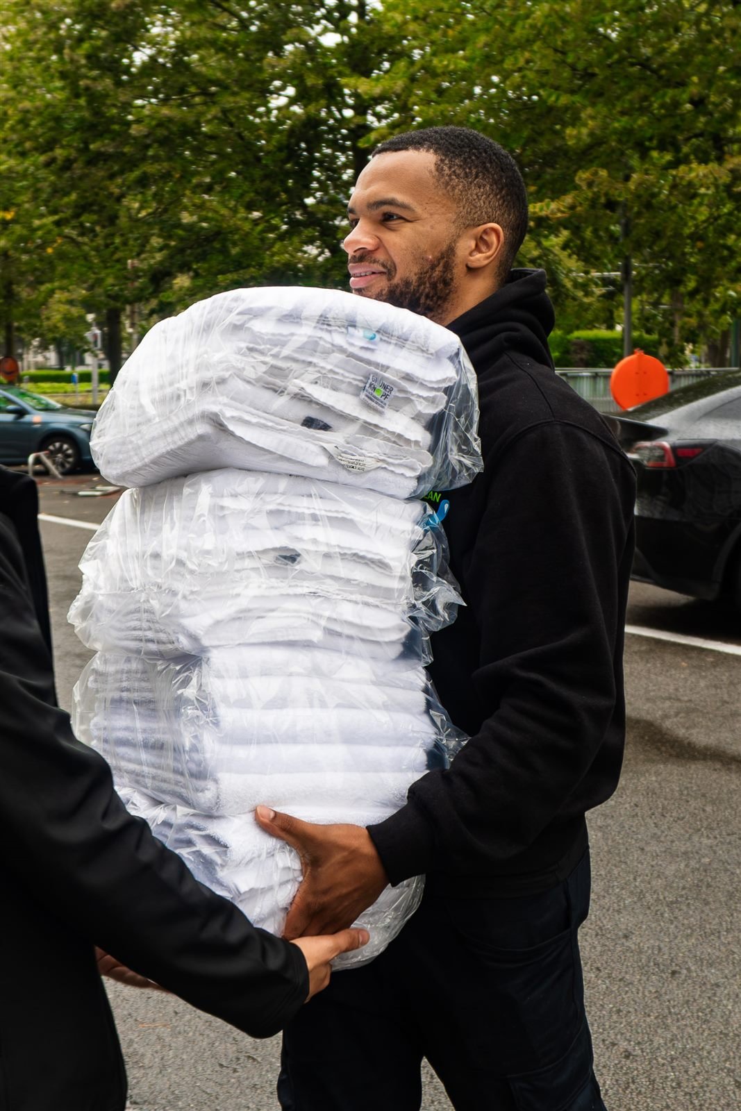 Livreur souriant portant du linge emballé