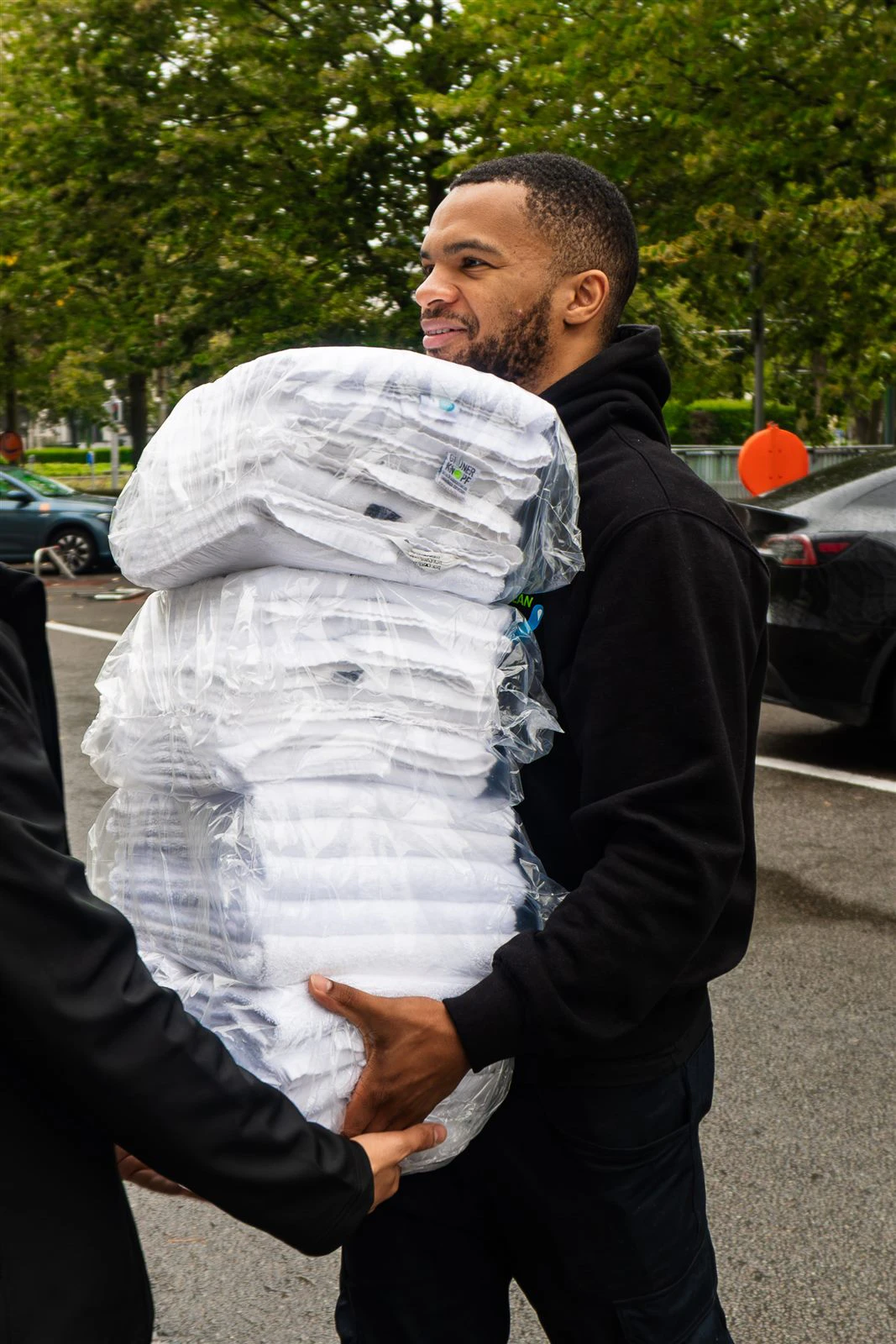 Livreur souriant portant du linge emballé
